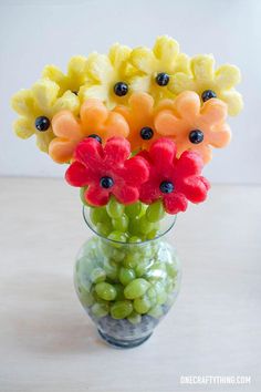 a vase filled with watermelon, grapes and gummy bears