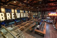 the inside of a building with many tables and benches in it, along with a large sign that says bre whale