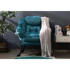 a blue chair sitting next to a white table with a potted plant on it