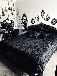 black and white photograph of a bedroom with mirrors on the wall, bed in foreground