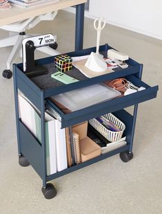 a blue rolling cart filled with office supplies