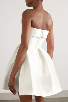 the back of a woman wearing a white dress