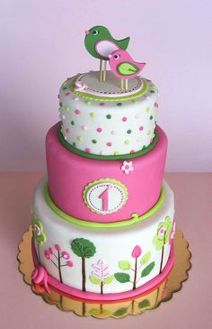 a three tiered cake with two birds on top and one bird sitting on top