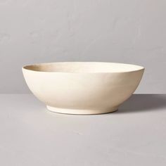 a large white bowl sitting on top of a gray countertop next to a wall