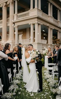 a bride and groom kiss as they walk down the aisle with confetti thrown in the air