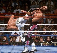 two men wrestling in front of an audience