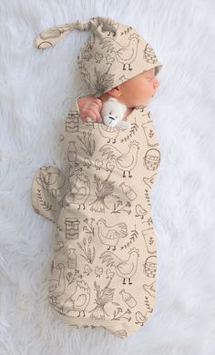 a baby wrapped in a sleeping bag with drawings on it