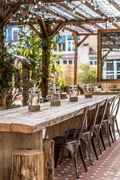 an outdoor dining area with wooden tables and chairs