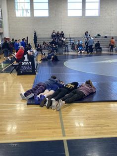 three people laying on the floor in a gym