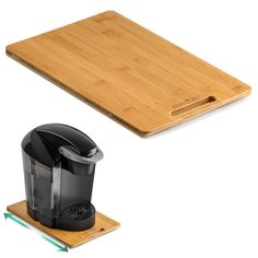 a bamboo cutting board with a black coffee cup on it and an electric grinder next to it