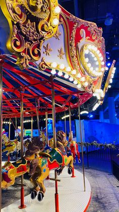 a merry go round ride at an amusement park with lights on it's sides