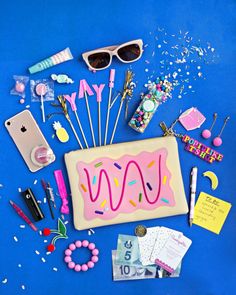 a blue table topped with lots of items and confetti on top of it