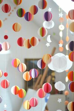 colorful paper balls hanging from strings in a room