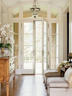 a living room filled with furniture and large windows