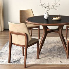 a dining room table with four chairs and a rug on the floor in front of it