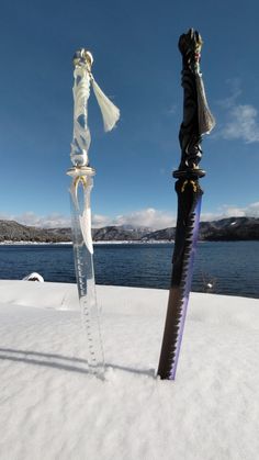 two swords that are standing in the snow