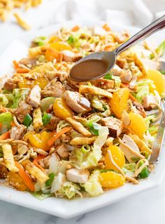 a white plate topped with salad and a spoon