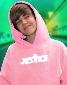 a young boy wearing a pink hoodie with the word justice on it's chest