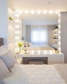 a white bedroom with lights on the wall