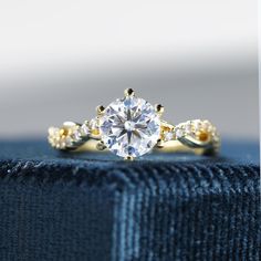 a close up view of a diamond ring on top of a blue piece of cloth