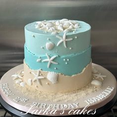 a birthday cake decorated with seashells and starfish