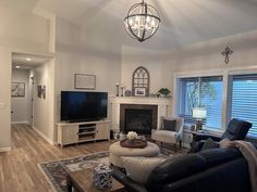 a living room filled with furniture and a flat screen tv on top of a wooden floor