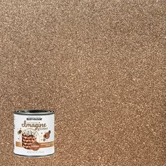 a can of paint sitting on top of a brown floor next to a white wall