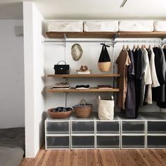 an organized closet with hanging clothes and baskets