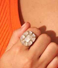 Generous curves, hexagonal lines, worked details; the sumptuous Reem ring in Mother-of-pearl is as much a technical feat as an aesthetic marvel. By borrowing its XXL shapes from those of a flower in full bloom, it lets its exceptional know-how, its multiple zircons and its fine natural stones shine. Cut nine times then polished by hand, these cabochons thus royally highlight the reflections, textures, tones and particularities of this extraordinary jewel. Delicate Rings, Pearl Size, Pearl Ring, Ring Necklace, Everyday Look, Ring Shopping, The Borrowers, Mother Of Pearl, Natural Stones