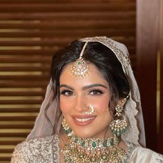 a woman wearing a bridal outfit and jewelry