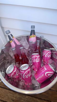 a metal bucket filled with pink soda cans