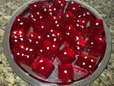 a bowl filled with red dices on top of a counter