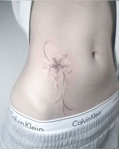 a woman's stomach with a flower tattoo on it