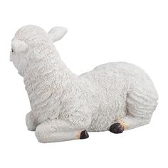 a white sheep laying down on the ground