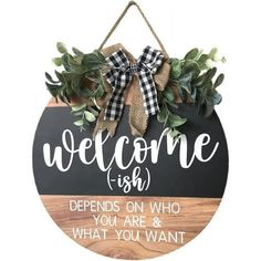 a welcome sign hanging from the side of a wooden plaque that says,'welcome fish defends on who you are & what you want '