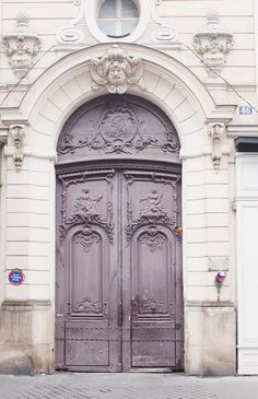 an old building with two large wooden doors