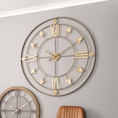 a large clock on the wall next to a chair