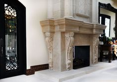 an ornate fireplace in the middle of a living room with white tile flooring and black doors