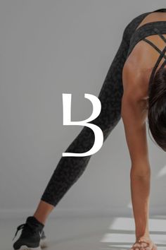 a woman in black sports bra and leggings doing a handstand