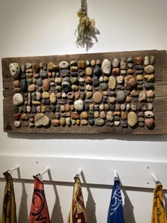 several towels are hanging on the wall next to some rocks and stones that look like they have been made out of wood