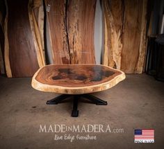 a wooden table sitting on top of a black metal stand in front of some wood boards