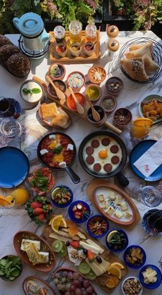 a table filled with lots of food on top of a white cloth covered tablecloth