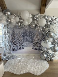 a room decorated with silver and white balloons