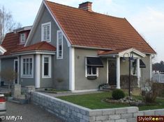 a gray house with red roof and white trim