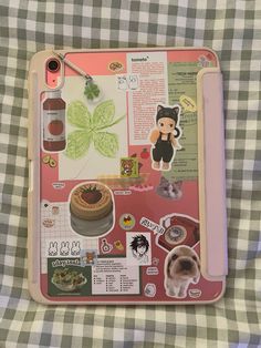 a pink tray with various stickers and pictures on it sitting on a checkered table cloth