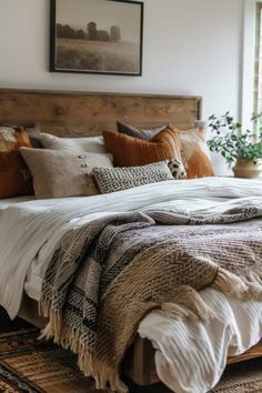 a bed with pillows and blankets on top of it in a bedroom next to a window