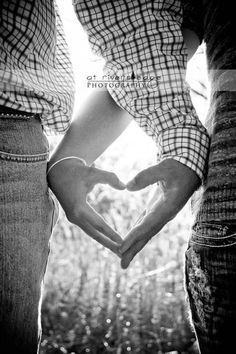 two people holding hands making a heart shape with their hands in front of each other