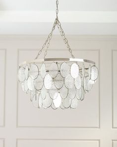 a chandelier hanging from a ceiling in a room with white paneled walls