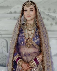 a woman in a purple and gold bridal outfit