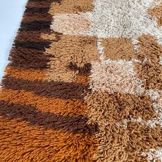 an area rug with various colors and patterns on it, including brown, white, tan and black